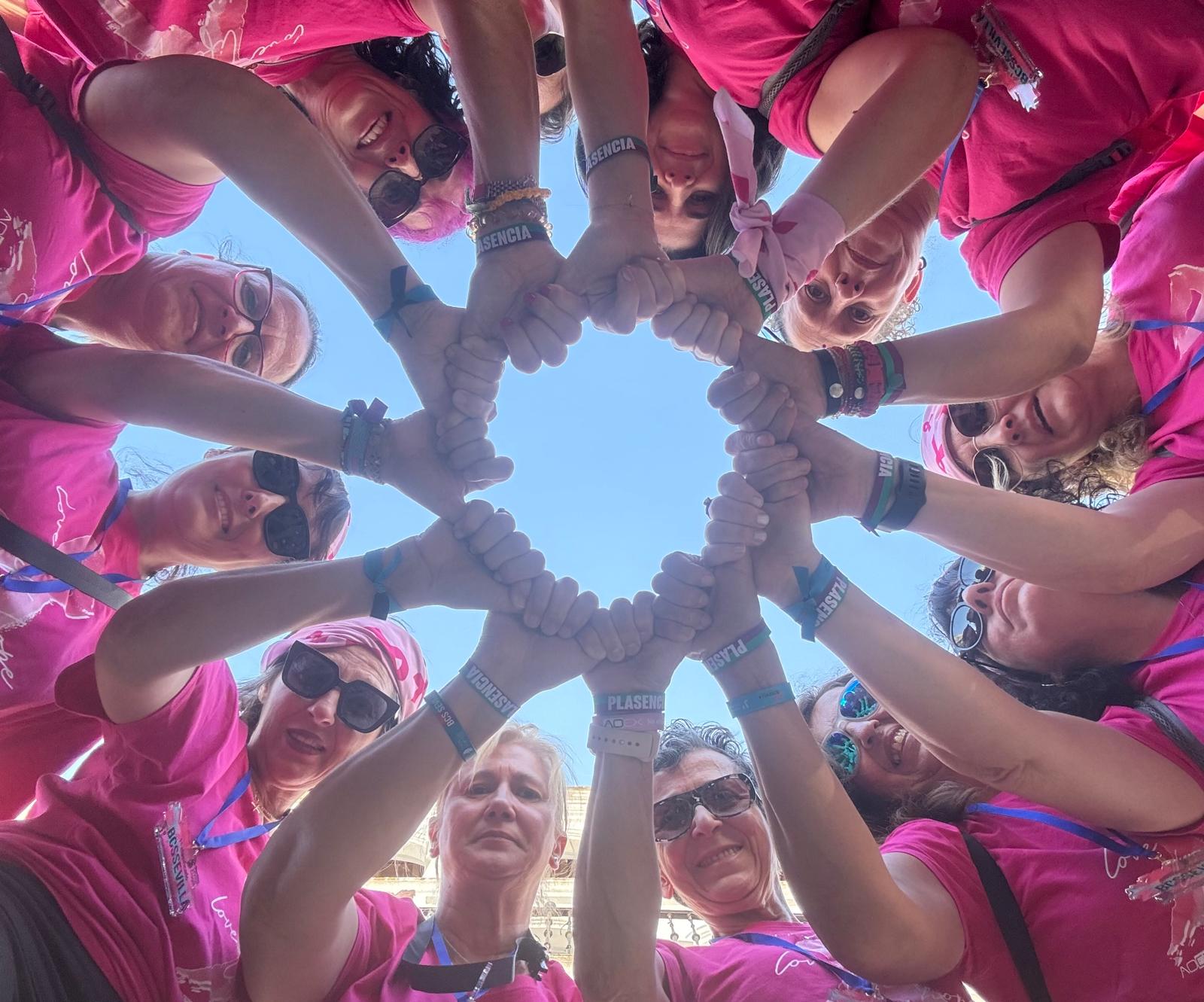Equipo uniendo las manos bajo el cielo